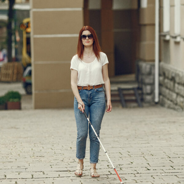 young-blind-person-with-long-cane-walking-in-a-city