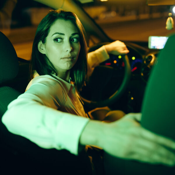young-woman-drives-car-in-a-reverse-at-night