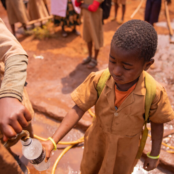 little-african-schoolgirl-collects-water-in-the-bottle